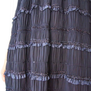 May include: A navy blue skirt with multiple layers of ruffles and a sparkly trim.