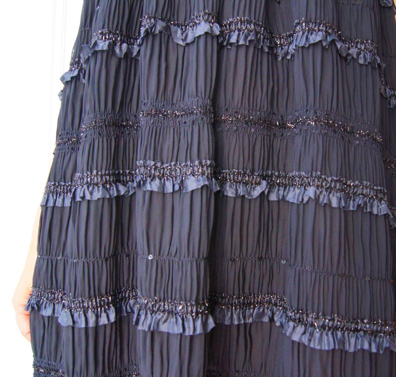 May include: A navy blue skirt with multiple layers of ruffles and a sparkly trim.