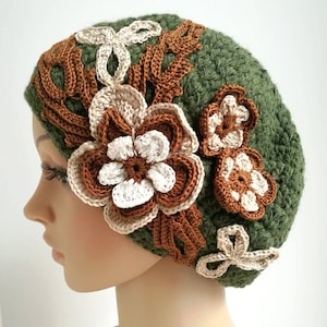 May include: A green crocheted beret with brown and white crocheted flowers.