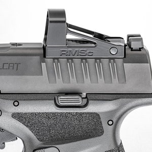 Puede incluir: Una pistola negra con una mira de punto rojo montada en la parte superior. La mira est&aacute; etiquetada como "RMSC". La pistola tiene un agarre texturizado y una corredera con "ELLCAT" grabado en ella.