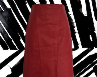 May include: A red leather skirt with a straight cut and a slightly flared hem. The skirt has a zipper closure and a high waist.