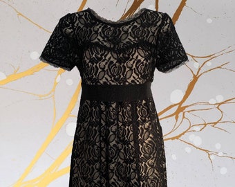 Empire Waist Little Black Lace Dress • Black Rose Pattern Lace over Beige Lining • 4 Faux Buttons at the Neck • Belt Ties in Back • Babydoll