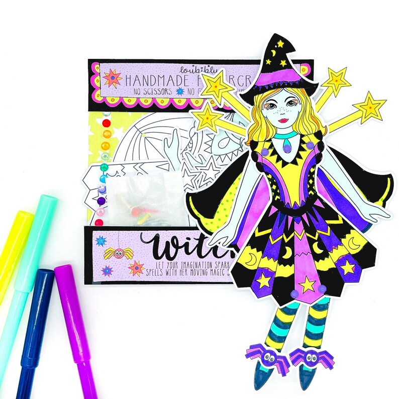 May include: A color-your-own witch doll craft kit with a purple, yellow, and black dress, a black witch hat, and a wand. The kit includes a sheet of stickers and a sheet of paper with a witch doll outline to color. The text on the packaging reads "loubibly HANDMADE NO SCISSORS. NO GLUE. RCR" and "WITCH LET YOUR IMAGINATION SPARK SPELLS WITH HER MOVING MAGIC STAR".