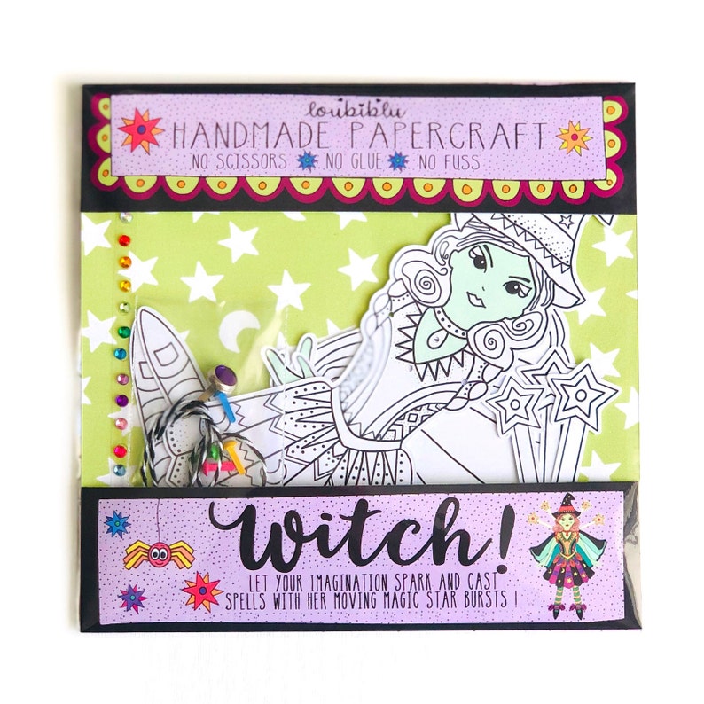 May include: A witch papercraft kit with a green and white witch illustration, a black spider, and a purple background. The text on the packaging reads "loubiblu HANDMADE PAPERCRAFT NO SCISSORS NO GLUE NO FUSS Witch! LET YOUR IMAGINATION SPARK AND CAST SPELLS WITH HER MOVING MAGIC STAR BURSTS!"