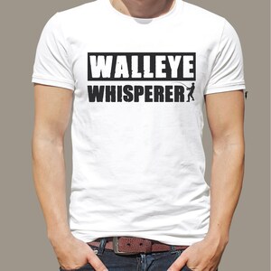 May include: White t-shirt with black text that reads "WALLEYE WHISPERER" and a silhouette of a person fishing.