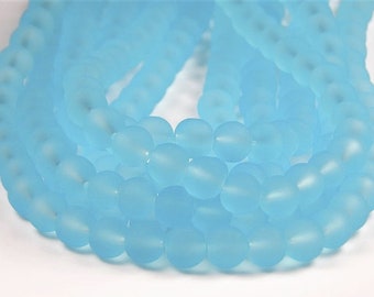 May include: A strand of light blue frosted glass beads. The beads are oval shaped and have a matte finish.