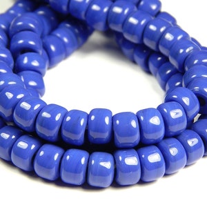 May include: A strand of bright blue glass beads. The beads are round and have a smooth, glossy finish.