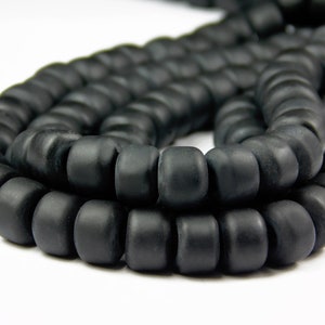 May include: A strand of black matte round beads. The beads are uniform in size and have a smooth, slightly textured surface.