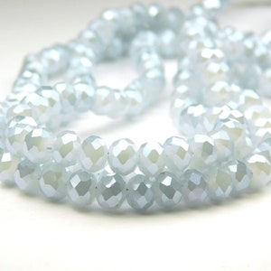 May include: A strand of light blue faceted glass beads. The beads are round and have a shiny finish.