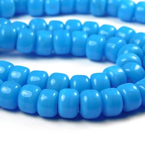 May include: A strand of light blue glass beads. The beads are round and have a smooth, glossy finish.