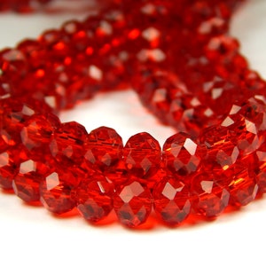 May include: A strand of red faceted glass beads. The beads are round and have a shiny finish.