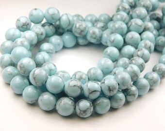 May include: A strand of light blue round beads with white marbling. The beads are smooth and glossy.