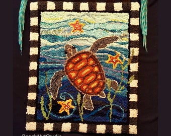 May include: A colorful rug depicting a sea turtle swimming in the ocean with starfish and seaweed. The rug has a black and white checkered border.