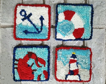 May include: Four square, nautical-themed coasters. Each coaster features a different design: an anchor, a life preserver, a crab, and a lighthouse. The designs are in red, white, and blue, with a blue border and red trim.