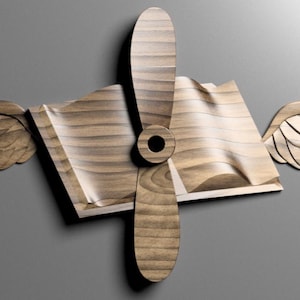 May include: A wooden sculpture of an open book with wings and a propeller in the center. The book and wings are made of light brown wood, while the propeller is a darker brown.
