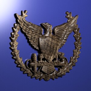 May include: A wooden carving of an eagle with a shield and an anchor, surrounded by a wreath of leaves. The eagle is holding a scroll in its talons.