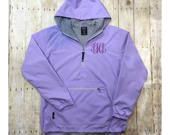 May include: A lavender pull-over jacket with a zipper and a hood. The jacket has a large pocket on the front and a monogrammed "SHC" on the chest.