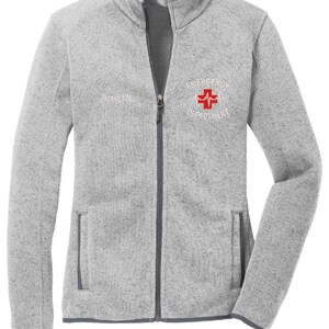 May include: A gray fleece zip-up jacket with a white embroidered logo that says "Emergency Department" with a red cross and a heartbeat symbol.