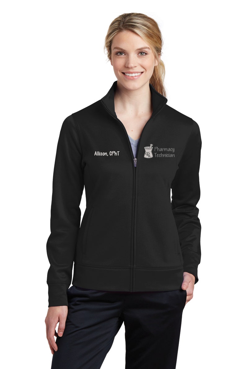 May include: Black zip-up jacket with the text "Allison, CPhT" and a pharmacy technician logo. The jacket has a high collar and a full-length zipper. The sleeves are long, and the jacket appears to be made of a smooth, athletic material.