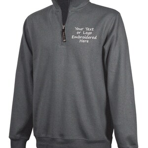May include: A charcoal gray 1/4 zip pullover sweatshirt with a white embroidered design that says "Your Text or Logo Embroidered Here".