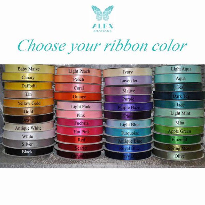 Peut inclure: Plusieurs bobines de ruban de diff&eacute;rentes couleurs, notamment jaune, rose, bleu et vert. L'image pr&eacute;sente le texte "Choisissez votre couleur de ruban" et un logo avec un papillon.