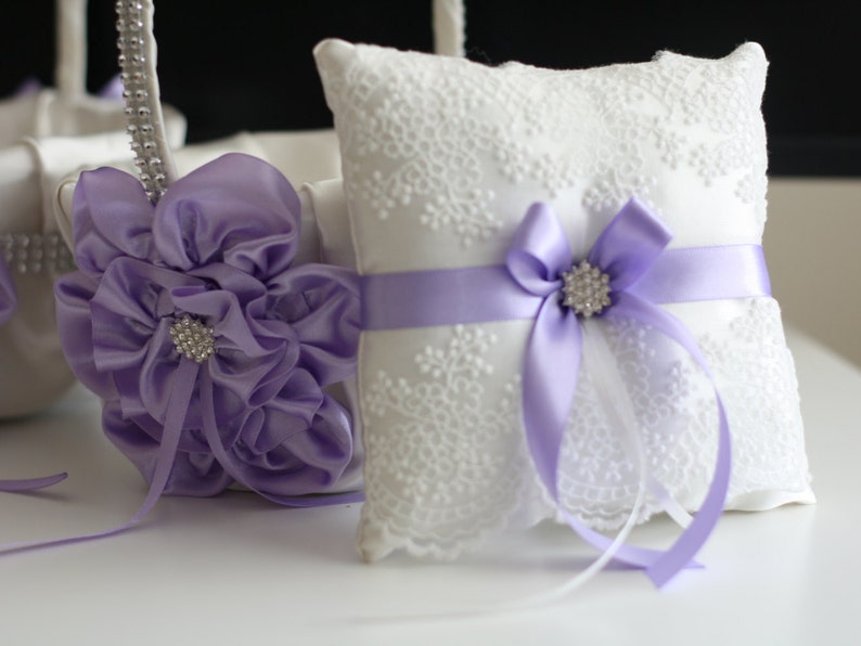 Purple-themed wedding ceremony supplies - purple flower girl basket and ring bearer pillow.