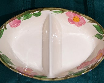 May include: A white divided serving dish with a floral design featuring pink roses and green leaves. The dish is oval shaped and has two sections.