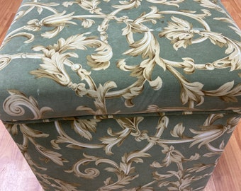 May include: A green and brown patterned storage ottoman with a square top and a wooden base.