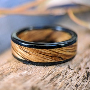 Peut inclure: Une bague en bois avec un incrustation d'époxy noir. Le bois a un motif de grain naturel et l'époxy est lisse et brillant.