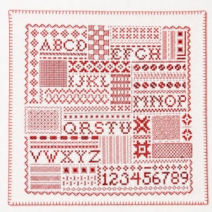 以下が含まれることがあります： 赤いクロスステッチ刺繍が施された正方形の白い布製サンプラー。AからZまでのアルファベット、1から9までの数字、そして様々な幾何学模様、縁取り、装飾的なステッチのモチーフがグリッド状に配置されたデザインです。