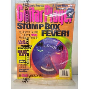 May include: A vintage issue of "Guitar Player" magazine, featuring a cover with the headline "Stomp Box Fever!" and a graphic of a "Fuzz Face" pedal. The magazine is sealed in plastic.
