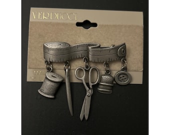 Broche Verducci en étain sur le thème de la couture avec ruban à mesurer et breloques