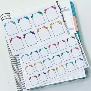 May include: Two sheets of planner stickers featuring white squares with colorful corner accents. The stickers are arranged on a spiral-bound planner. The text "SWEET TIDE DESIGNS" and social media handles are visible on the planner.