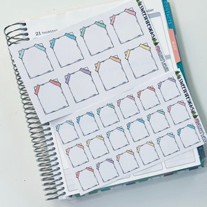 May include: A sheet of colorful planner stickers with a variety of pastel colored frames. The frames are outlined in black and have a small ribbon at the top corner. The stickers are perfect for adding a touch of color and organization to your planner.