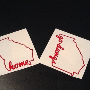 May include: Two white vinyl stickers with the outline of the state of Georgia. One sticker says "home" and the other says "godawgs".