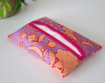 May include: A rectangular tissue box cover with a floral pattern in shades of purple, peach, and red. The cover has a bright pink ribbon detail and a white tissue opening.