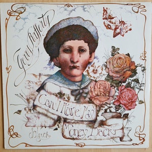 Può includere: Una copertina di un album in vinile vintage con un giovane ragazzo con un'espressione triste, che indossa una camicia da marinaio e tiene un mazzo di rose. Il titolo dell'album è "Can I Have My Money Back" di Gerry Rafferty.