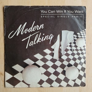 Może przedstawiać: Czarno-biała okładka płyty winylowej z tekstem "You Can Win If You Want" i "Special Single Remix" na górze. Zespół "Modern Talking" jest napisany białymi literami kursywą na czarnym tle. Dolna część okładki przedstawia czarno-biały wzór w szachownicę z białymi butami i białymi kulami.