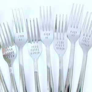Puede incluir: Seis tenedores de plata con diferentes lemas grabados. Los lemas son "Fork It", "Zero Forks Given" y "Zero Forks Given".