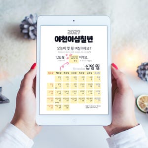 May include: A white tablet displaying a 2027 Korean language calendar page for November. The screen features the year 2027, the month in Korean, and a grid of dates with Korean text. The interface includes educational phrases and a small star graphic.
