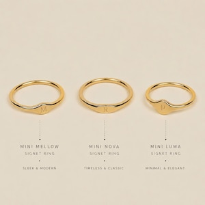 May include: Three gold-toned signet rings arranged horizontally. The left ring is labeled Mini Mellow with the letter M, the center is Mini Nova with the letter R, and the right is Mini Luma with the letter P. Each ring features a thin band.