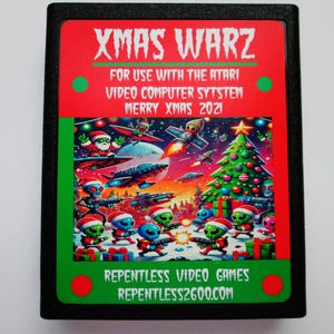 May include: A black rectangular Atari video game cartridge titled XMAS WARZ. The label features a colorful illustration of green aliens in Santa hats holding blasters, a decorated Christmas tree, and spaceships. Text includes FOR USE WITH THE ATARI VIDEO COMPUTER SYTSTEM MERRY XMAS 2021 and REPENTLESS VIDEO GAMES REPENTLESS2600.COM.