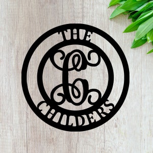 May include: Black metal circle sign with the text "The Childers" and a decorative letter "C" in the center.