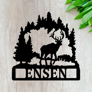 May include: Black metal silhouette of a deer standing in a forest with a custom nameplate that reads "ENSEN".