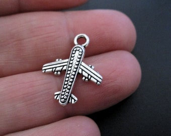 May include: Silver airplane charm with a detailed design. The charm is perfect for adding a travel theme to jewelry or crafts.