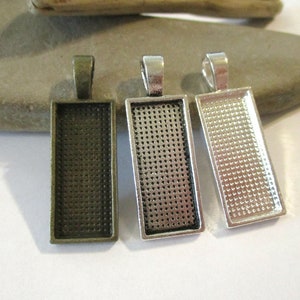 May include: Three rectangular pendant trays with a textured surface. The trays are in antique brass, silver, and antique silver finishes.