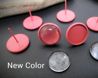 May include: A close-up of pink and clear glass earring settings. The settings are round and have a metal post for attaching to an earring.