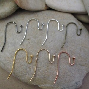 May include: Six earring hooks in different finishes: silver, gold, and rose gold. The hooks are all the same size and shape, with a small loop at the top and a small ball at the bottom.