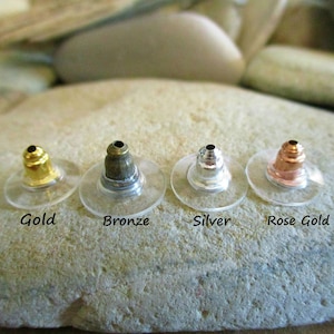 May include: Four earring backs in gold, bronze, silver, and rose gold.