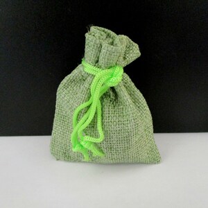 May include: A small green burlap drawstring bag with a bright green drawstring.